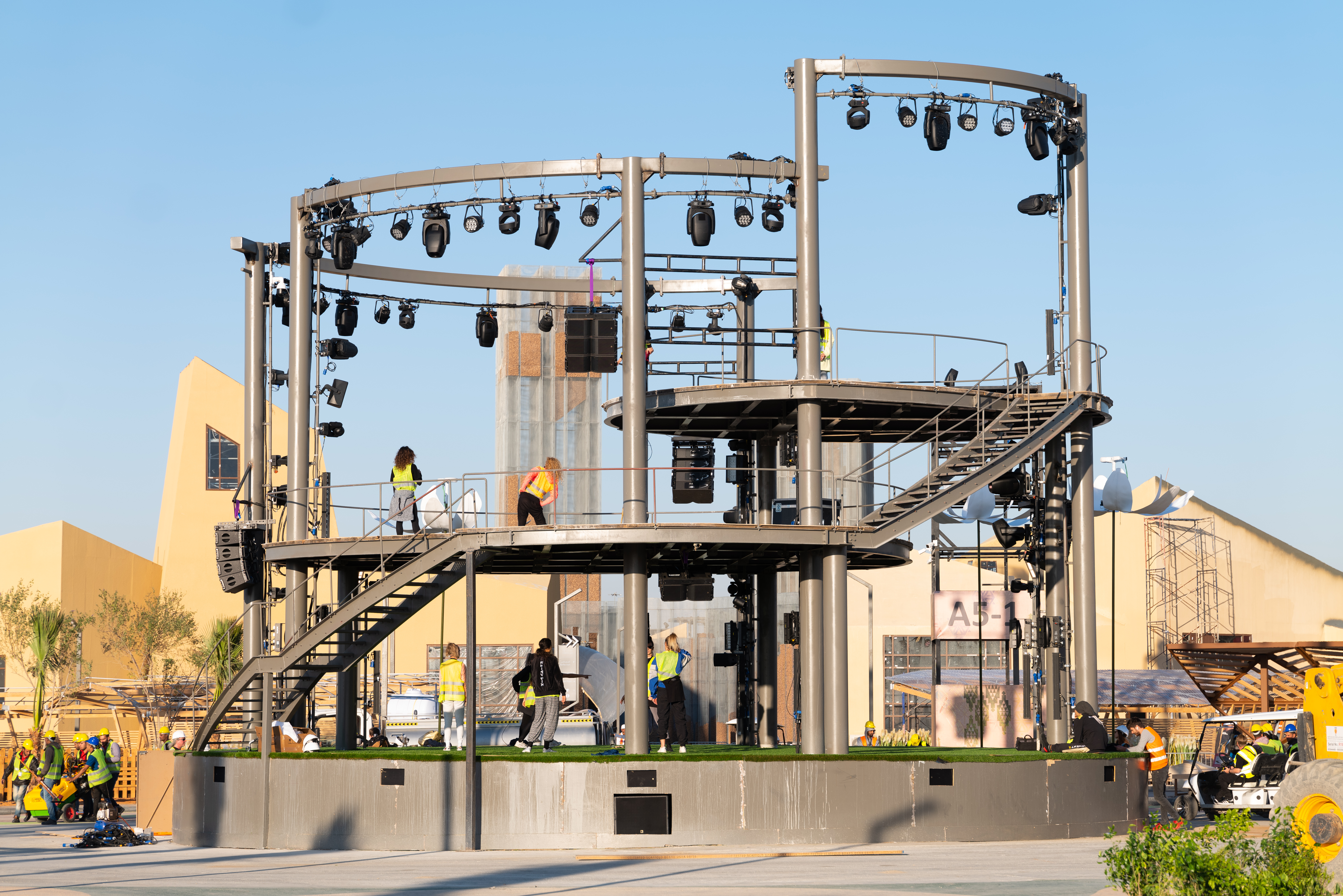 Large scenic stage combining primary steelwork, secondary framing, decking and overhead structural systems.