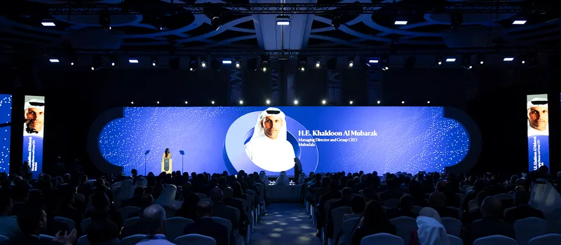 Wide central LED screen framed by five-metre painted scenic structures in Abu Dhabi.