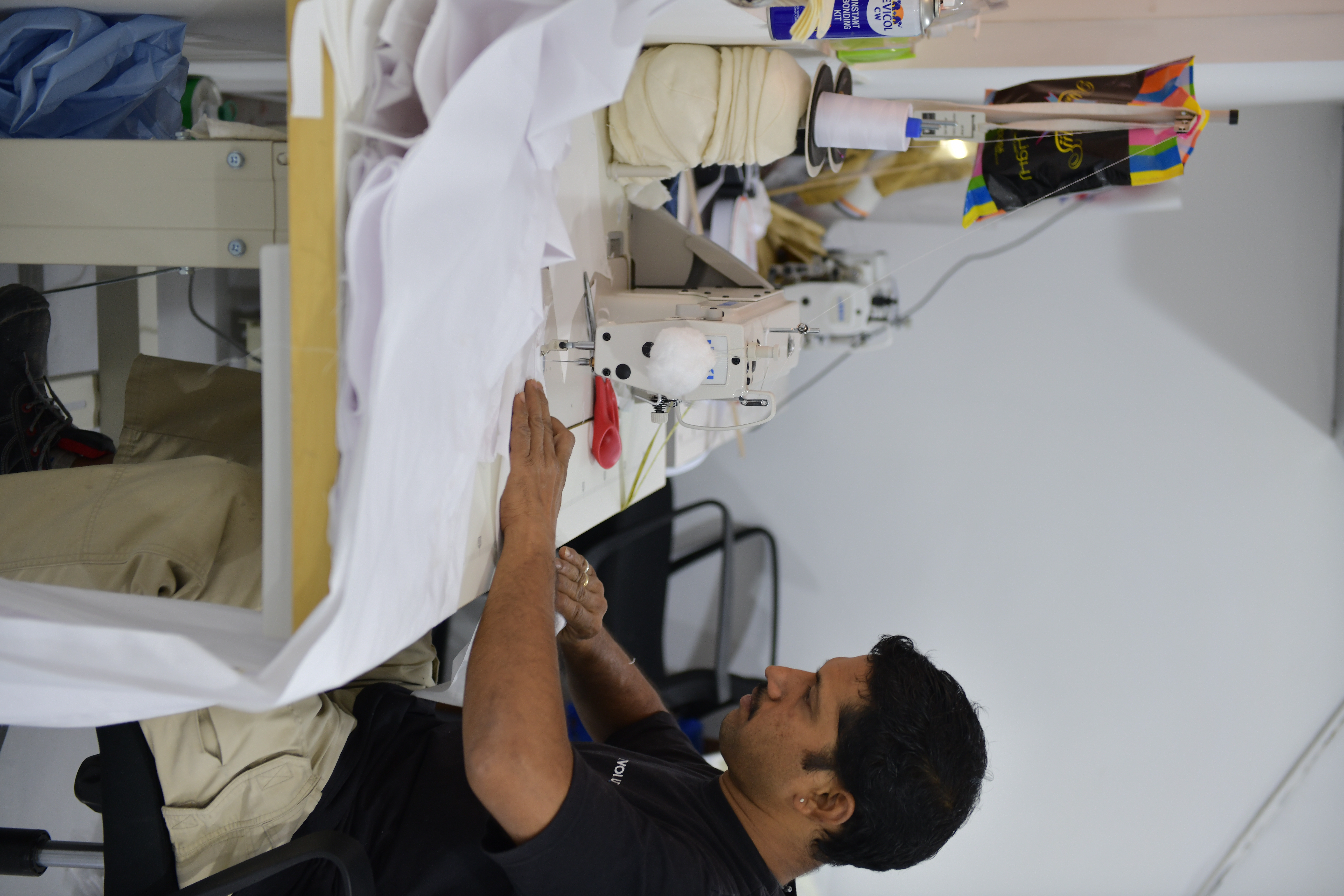 Industrial sewing machine producing reinforced flame-retardant scenic drapery in the workshop.

