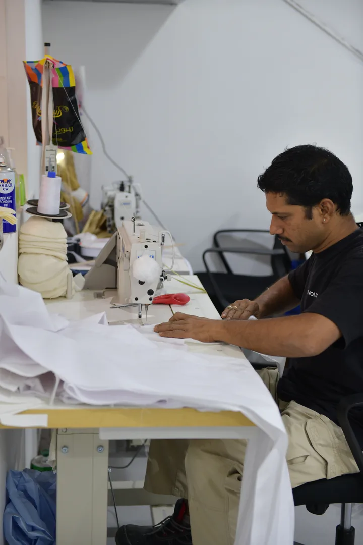 Industrial sewing machine producing reinforced flame-retardant scenic drapery in the workshop.
