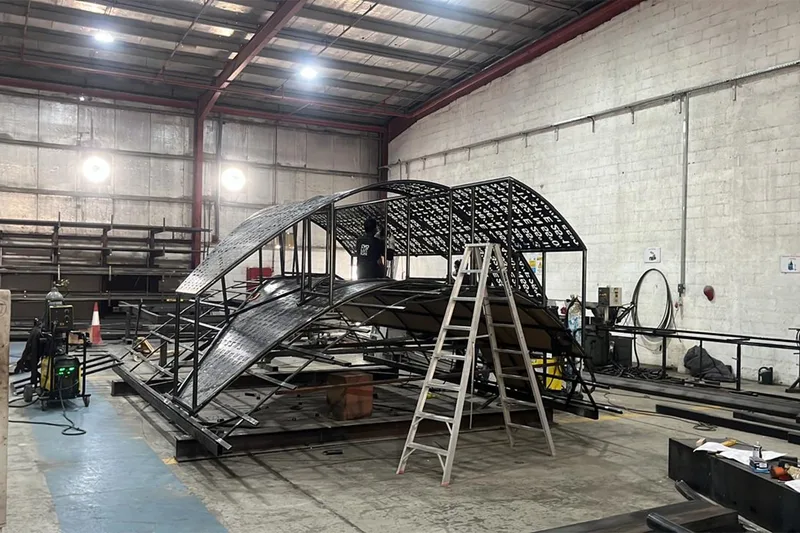 Ambitious scenic structure under fabrication with exposed carpentry and metal framework