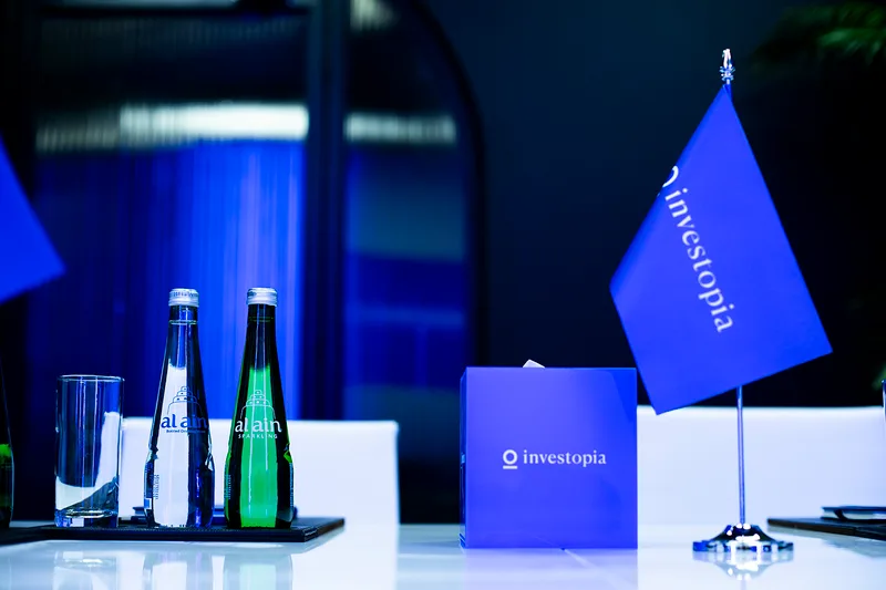 Evolution Scenic branded tabletop flag and display cube for the Investopia meeting environment.
