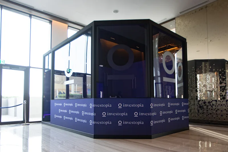Branded TV studio backdrop constructed for Investopia interviews in the pre-function area.
