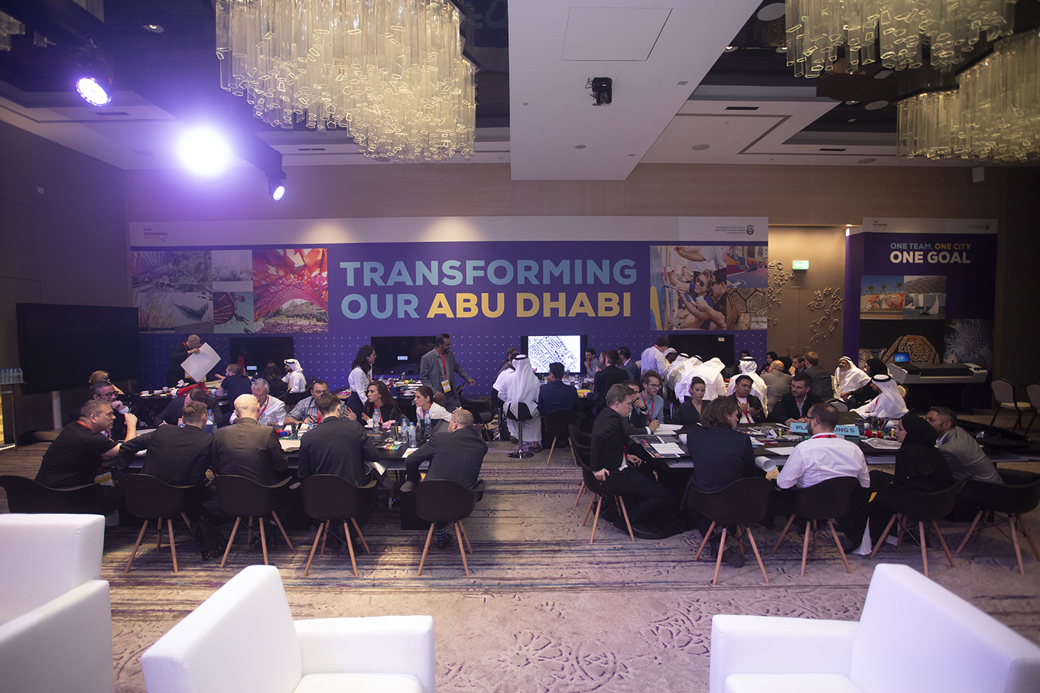 Large printed perimeter walls dividing workshop zones inside the hotel ballroom.