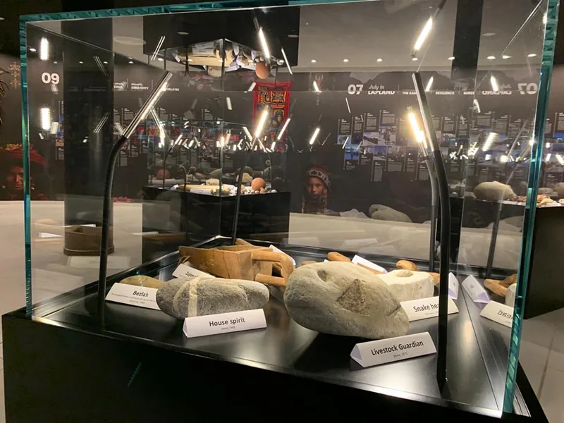 Illuminated glass display case mounted on a custom black scenic base.