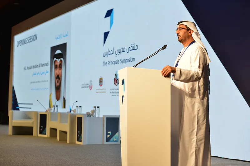 Speaker at a custom lectern on the main stage with integrated symposium screen graphics in Dubai.