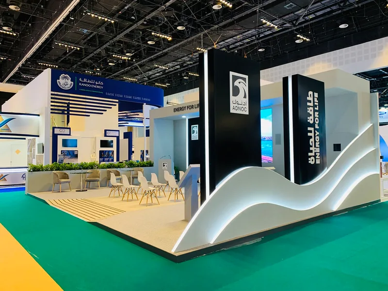 Custom MDF exhibition construction with bilingual ADNOC branding and integrated LED display technology