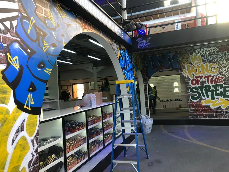 Evolution Scenic urban-themed retail stand featuring multi-level scenic construction and branded façades.