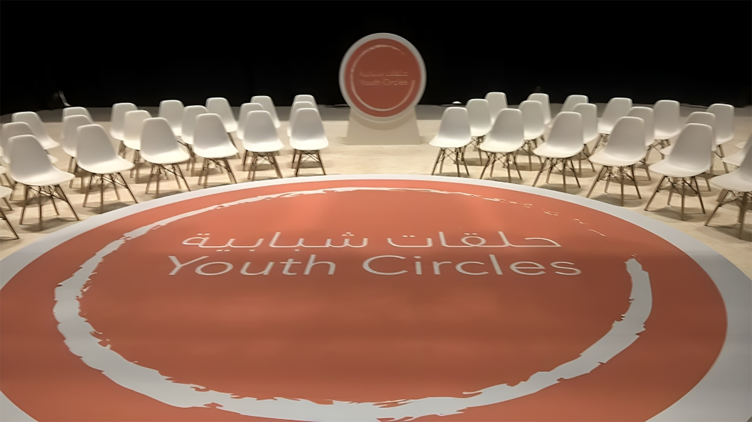 Circular orange floor graphic integrated into the custom low-profile scenic platform.