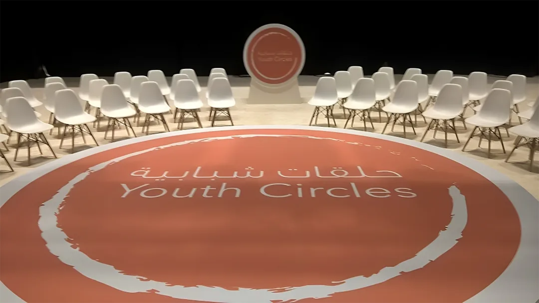 Circular orange floor graphic integrated into the custom low-profile scenic platform.