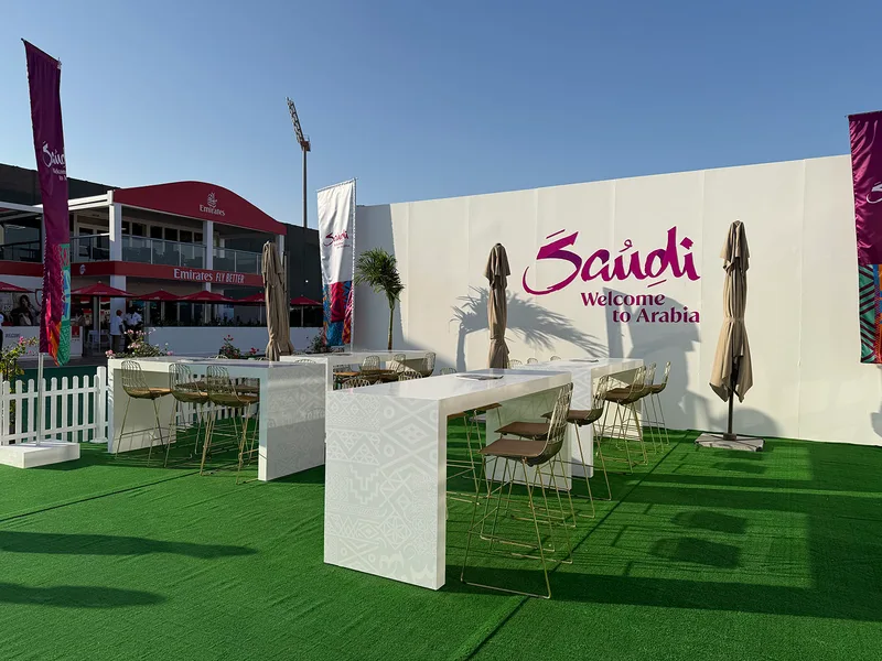 Outdoor high tables with Arrow barstools beneath cantilever umbrellas at the entrance.