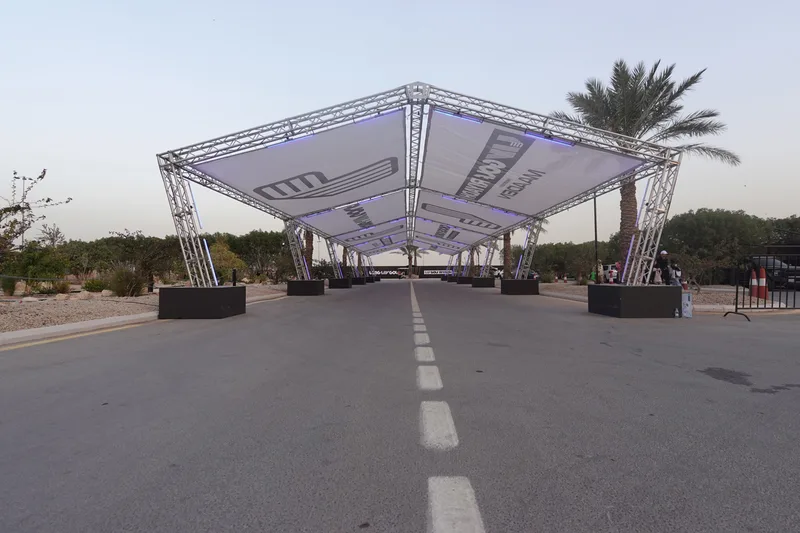 Branded truss canopy with custom base covers and printed fabric panels at LIV Golf Riyadh 2025.
