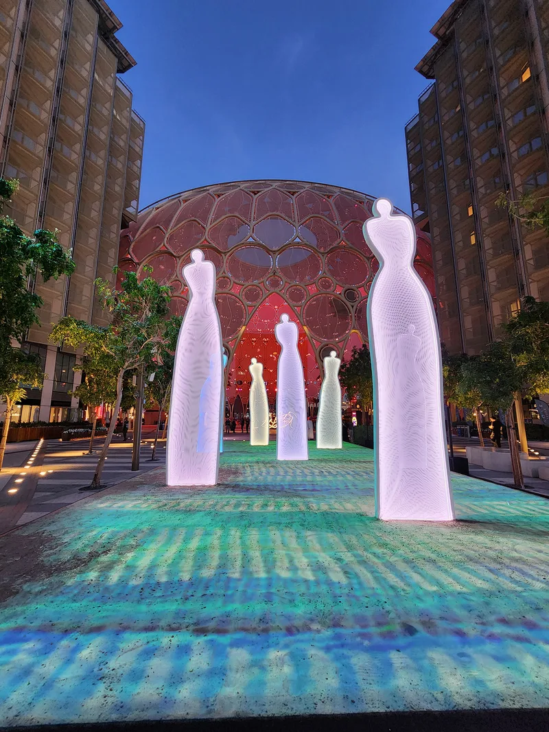 Interconnected base plates securing seven illuminated fabric figures across the temporary landscape.