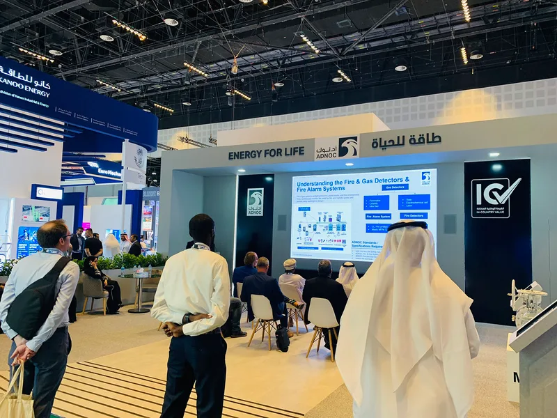Painted MDF scenic walls carrying ADNOC Energy for Life branding within the Abu Dhabi exhibition stand