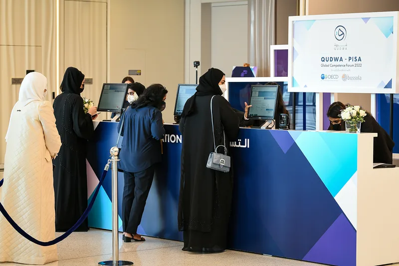 Evolution Scenic branded reception counter with vinyl graphics for the Qudwa–PISA Forum at Expo 2020 Dubai.
