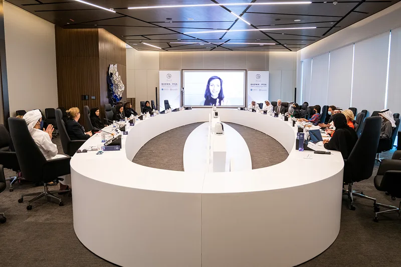 Qudwa–PISA conference meeting environment with circular table, branded banners and integrated display screen.