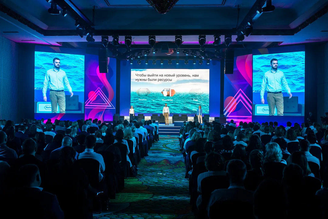 Integrated LED screens framed by custom Roche conference scenery in Dubai.