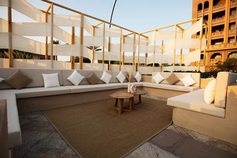 Evolution Scenic round outdoor seating structure with white timber frame and fabric infill.