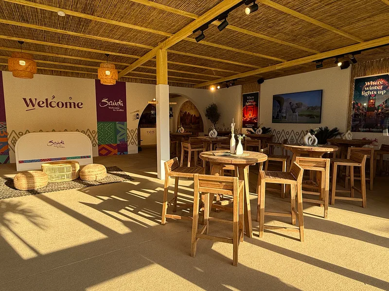 Branded wall graphics and mounted television screens within the temporary hospitality structure.