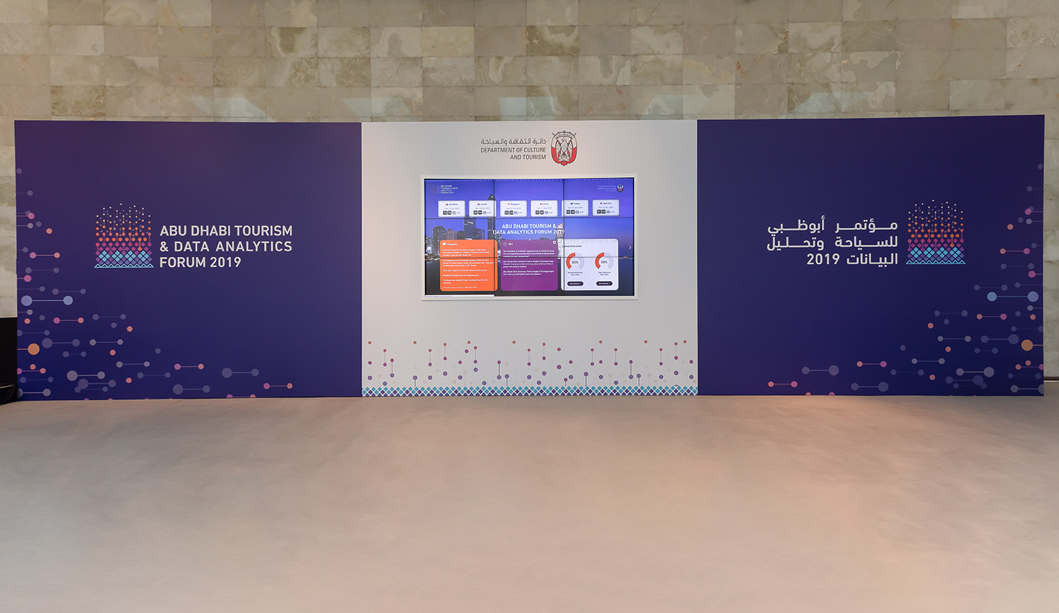 Scenic backdrop walls framing the principal conference presentation area in Abu Dhabi.