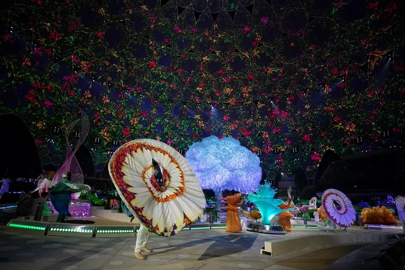 Group of illuminated kinetic flowers displaying varied blooming profiles and sculptural proportions.