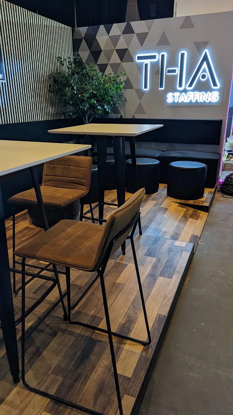 THA Stand seating zone framed by slatted scenic joinery and black furniture.
