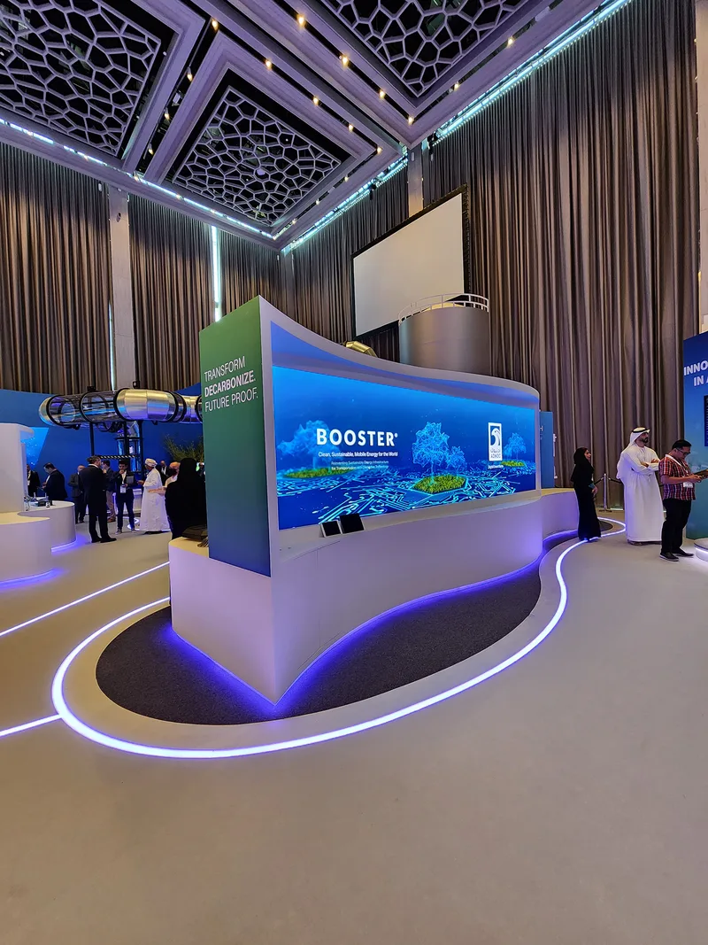 Sponsor booth featuring reflective flooring, LED strips and printed graphic wall treatments.