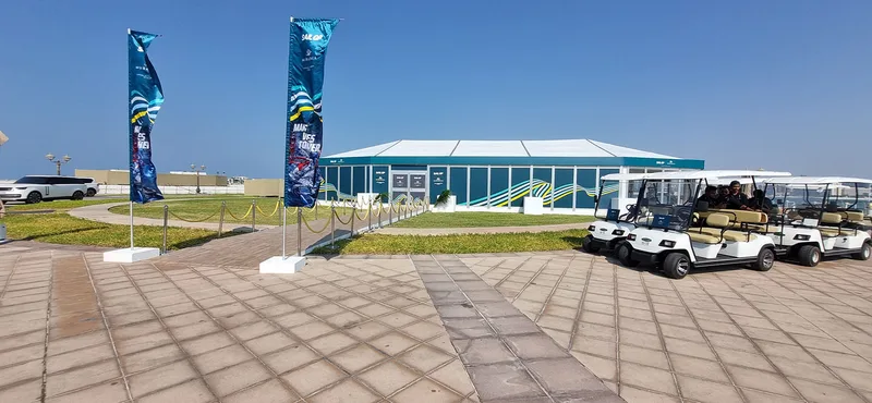 Square-based branded flags defining the entrance to the temporary waterfront venue.