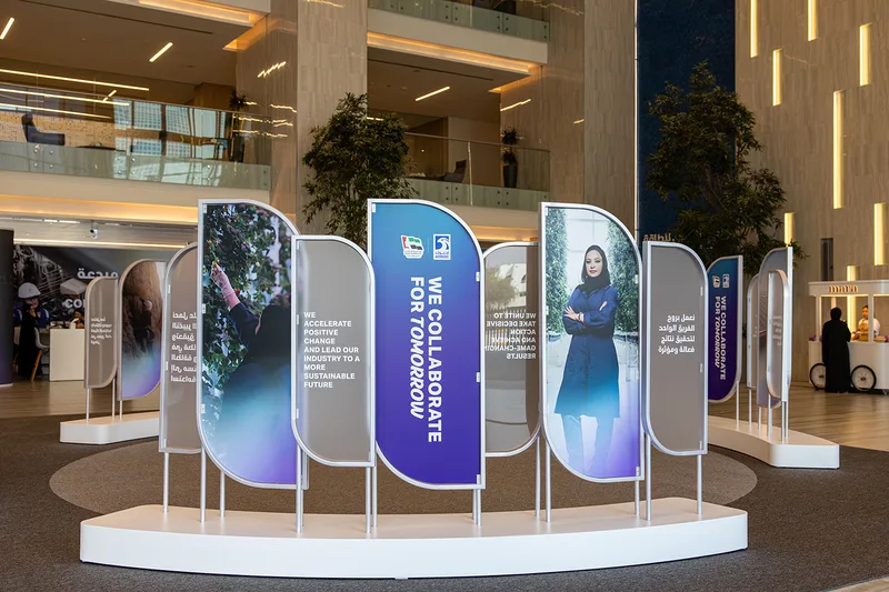 Steel picture-frame installation with layered graphic panels on a raised scenic base.