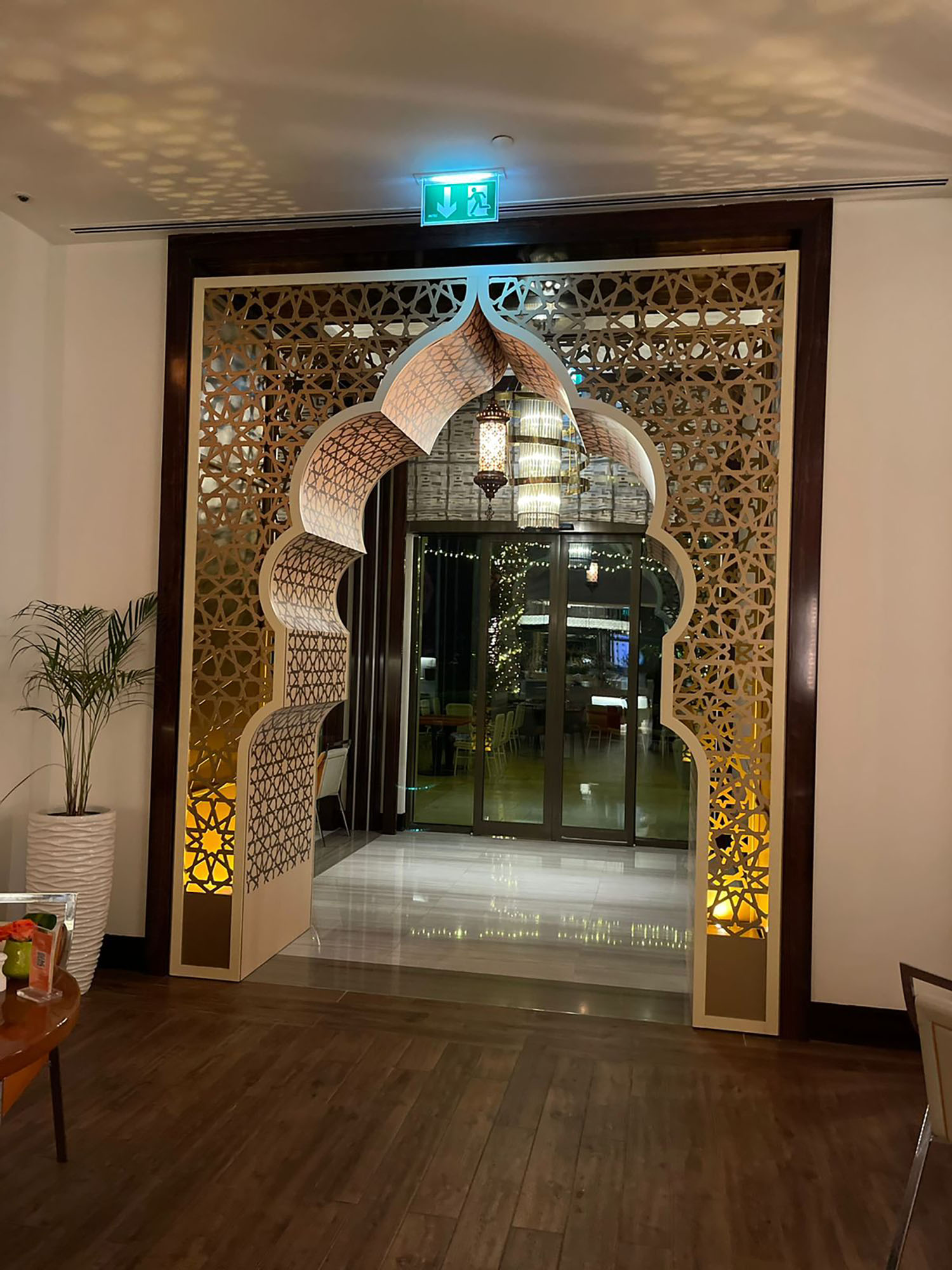 Decorative walkway portal repeating the mashrabiya language throughout the hospitality interior.