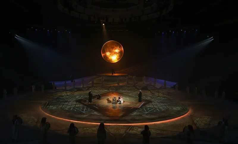 Terhal by Dragone performers staged beneath a suspended glowing sphere on the circular arena set in Riyadh.