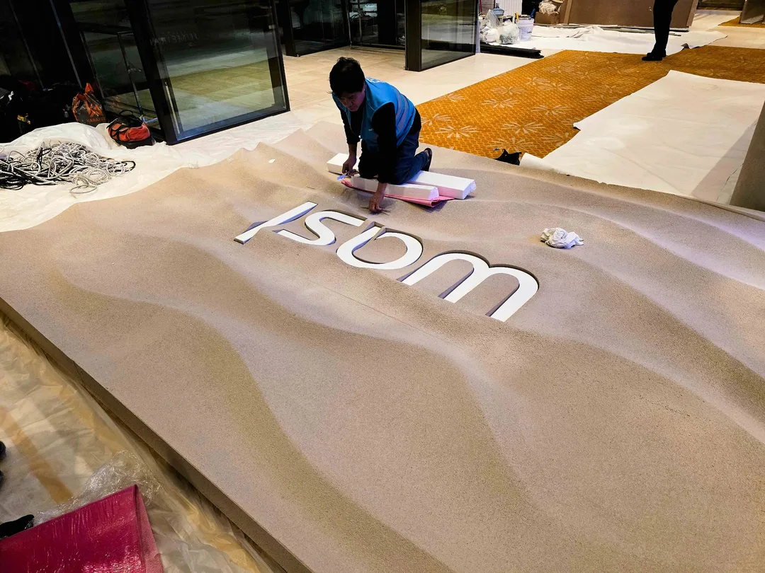 Evolution Scenic painter applying a controlled camera-facing topcoat to a fabricated scenic panel.