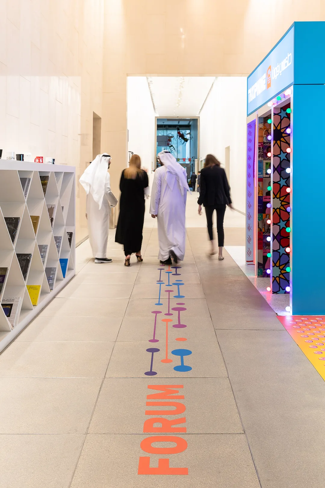 Floor-applied wayfinding graphics connecting the forum’s scenic presentation areas.
