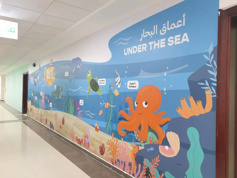 Evolution Scenic illustrated undersea learning graphic installed along a school corridor wall.