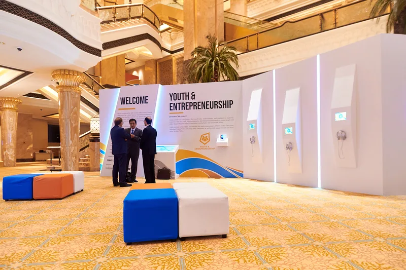 UNIDO exhibition scenic panel with integrated display screen and custom information graphics in Abu Dhabi.