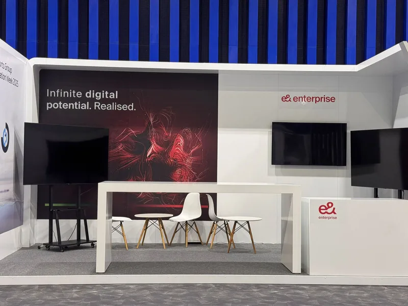Six-metre exhibition booth with rear worktop and fitted storage cabinetry.