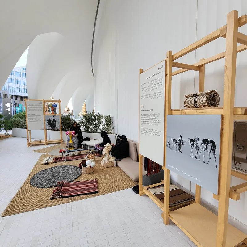 Open timber display bays combining shelving, archive photography and cultural objects.