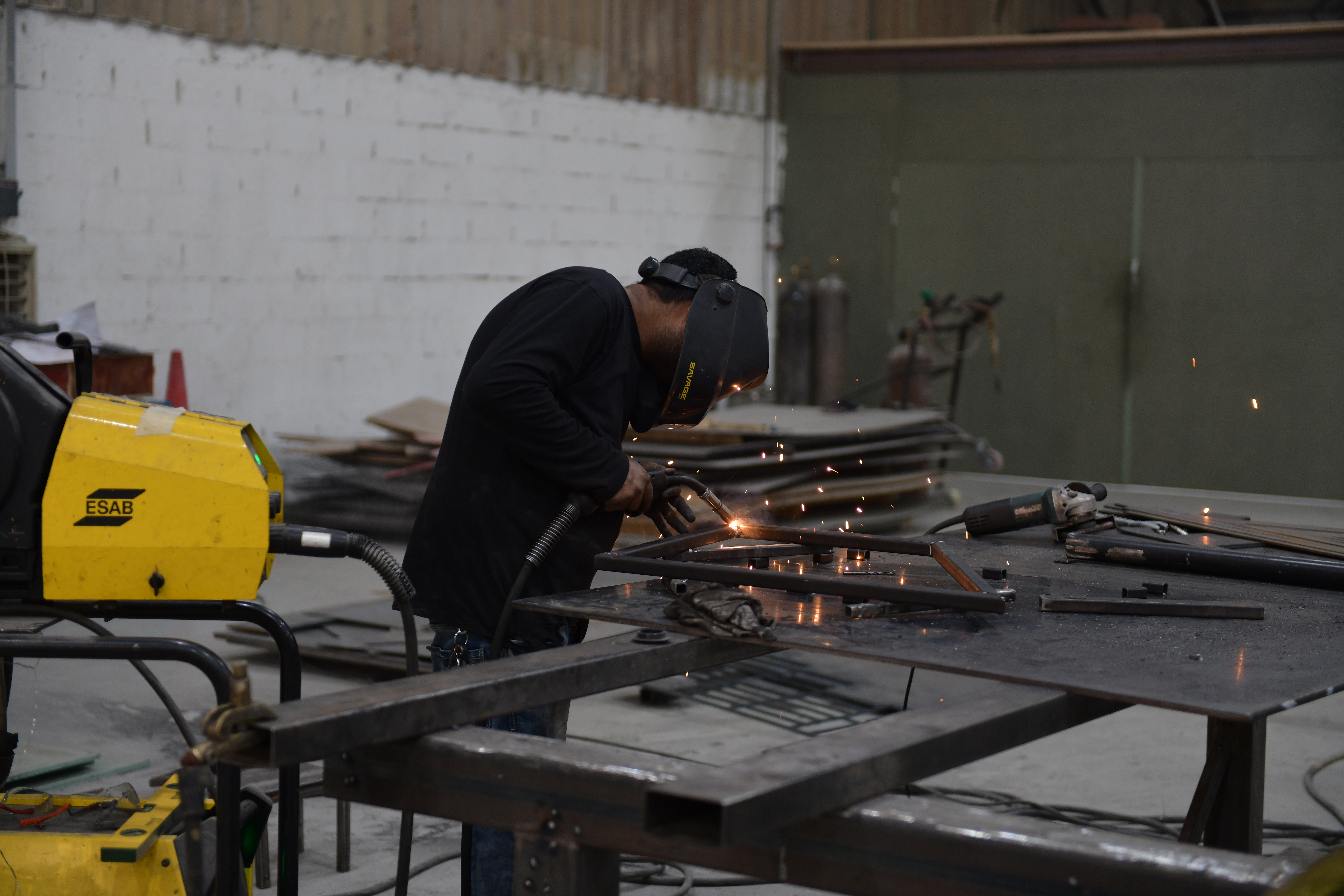 Skilled fabricator welding large scenic steel assembly using a controlled sequence to limit distortion
